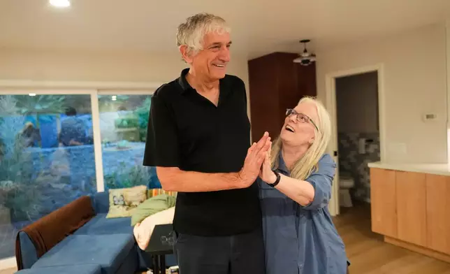John Martinis stands with his wife Jean in their living room after winning the Nobel Prize in Physics for his work on quantum tunneling on Tuesday, Oct. 7, 2025, in Santa Barbara, Calif. (AP Photo/Mark J. Terrill)