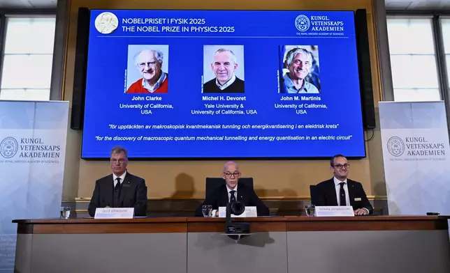 From left, Chair of the Nobel Committee for Physics Chair Olle Eriksson, Secretary General of the Swedish Academy of Sciences Hans Ellegren and Member of the Nobel Committee for Physics Goran Johansson announce John Clarke, Michel H Devoret and John M. Martinis, on screen behind, as the recipients the Nobel Prize in Physics, at the Nobel Assembly of the Karolinska Institutet, in Stockholm, Sweden, Tuesday, Oct. 7, 2025. (Christine Olsson/TT News Agency via AP)