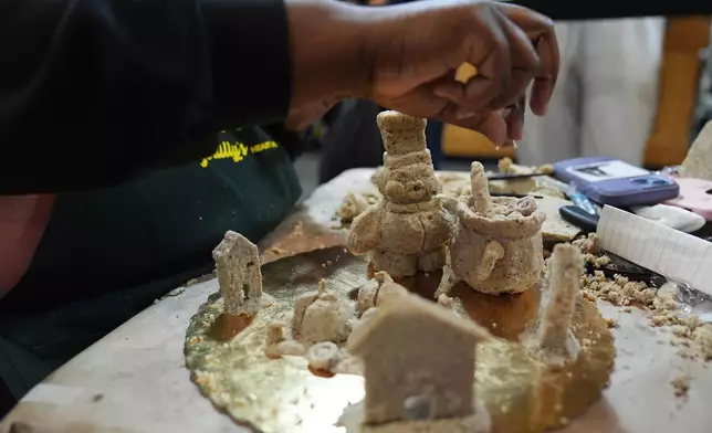 Toni Lee works on her entry to Scrapple Sculpting Contest at the Reading Terminal Market in Philadelphia, Friday, Oct. 10, 2025. (AP Photo/Matt Rourke)