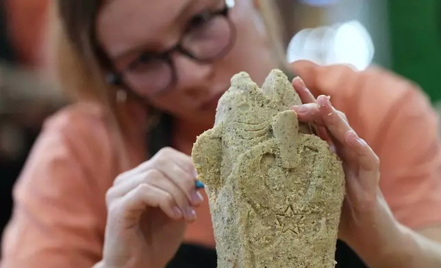 Victoria Roath works on her creation in the Scrapple Sculpting Contest at the Reading Terminal Market in Philadelphia, Friday, Oct. 10, 2025. (AP Photo/Matt Rourke)