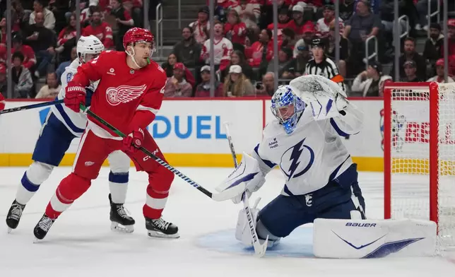 Tampa Bay Lightning goaltender Andrei Vasilevskiy (88) stops a Detroit Red Wings left wing James van Riemsdyk (21) shot as Erik Cernak (81) defends in the second period of an NHL hockey game Friday, Oct. 17, 2025, in Detroit. (AP Photo/Paul Sancya)