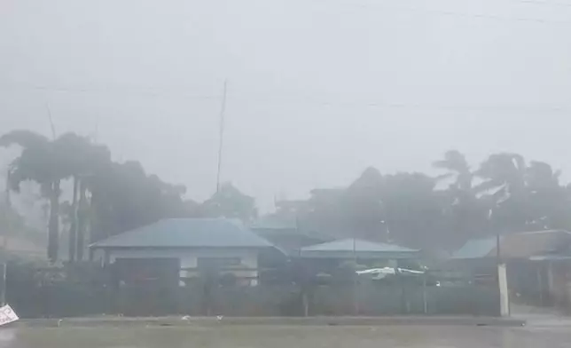 This grab from video shows buildings and trees being blown during storm in Dinapigue, Isabela province, Philippines, Friday, Oct.3, 2025. (Benson Ingaran Milare via AP)
