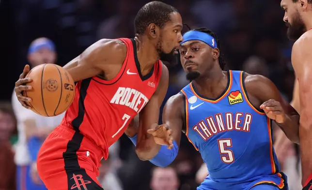 Houston Rockets forward Kevin Durant (7) drives against Oklahoma City Thunder guard Luguentz Dort (5) during the first half of an NBA basketball game Tuesday, Oct. 21, 2025, in Oklahoma City. (AP Photo/Nate Billings)