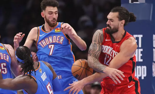 Houston Rockets center Steven Adams, right, tries to grab the ball next to Oklahoma City Thunder center Chet Holmgren (7) and guard Luguentz Dort (5) during the first half of an NBA basketball game Tuesday, Oct. 21, 2025, in Oklahoma City. (AP Photo/Nate Billings)