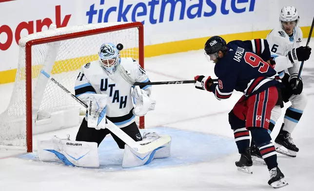 Utah Mammoth goaltender Vitek Vanecek (41) makes a save against Winnipeg Jets' Alex Iafallo (9) during the first period of an NHL hockey game in Winnipeg, Manitoba, Sunday, Oct. 26, 2025. (Fred Greenslade/The Canadian Press via AP)