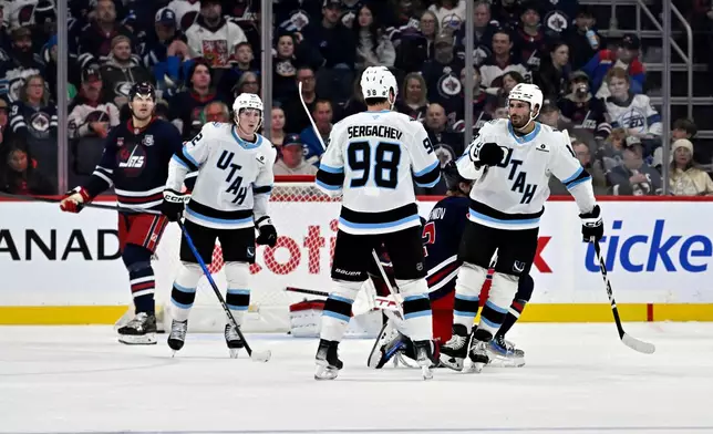 Utah Mammoth Mikail Sergachev (98) celebrates after his goal against the Winnipeg Jets with Nick Schmaltz (8) during the second period of an NHL hockey game in Winnipeg, Manitoba, Sunday, Oct. 26, 2025. (Fred Greenslade/The Canadian Press via AP)