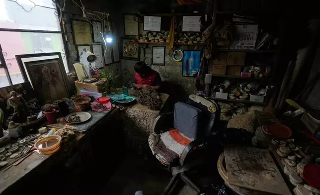 Mexican craftsman Luis Hernandez works on a fragile clay piece at his atelier in Metepec, Mexico, Thursday, Oct. 9, 2025. (AP Photo/Fernando Llano)