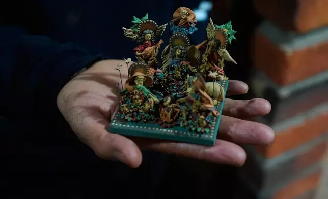 Mexican craftsman Cecilio Sanchez shows one of his miniature clay pieces at his atelier in Metepec, Mexico, Thursday, Oct. 9, 2025. (AP Photo/Fernando Llano)