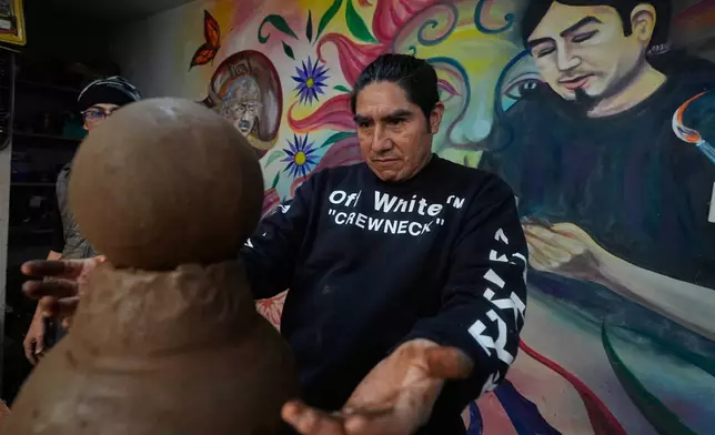Mexican craftsman Cecilio Sanchez works on a clay piece at his atelier in Metepec, Mexico, Thursday, Oct. 9, 2025. (AP Photo/Fernando Llano)