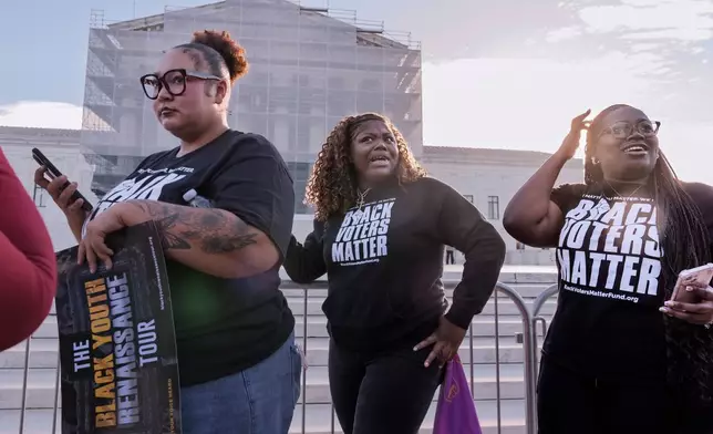 Voting rights activists gather outside the Supreme Court in Washington, early Wednesday, Oct. 15, 2025, as the justices prepare to take up a major Republican-led challenge to the Voting Rights Act, the centerpiece legislation of the Civil Rights Movement. (AP Photo/J. Scott Applewhite)
