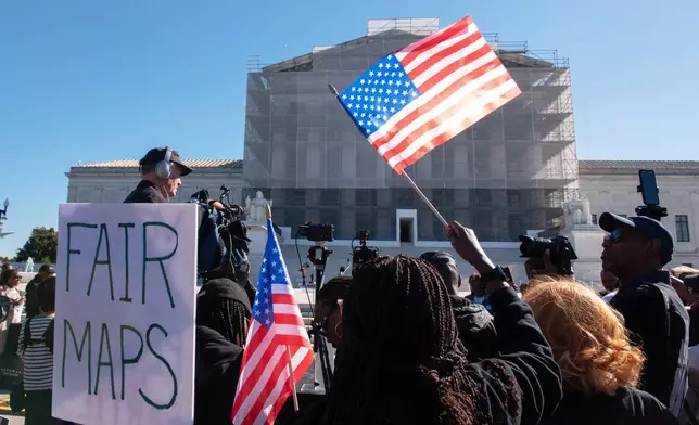 Voting rights activists gather outside the Supreme Court in Washington, early Wednesday, Oct. 15, 2025, as the justices prepare to take up a major Republican-led challenge to the Voting Rights Act, the centerpiece legislation of the Civil Rights Movement. (AP Photo/Cliff Owen)