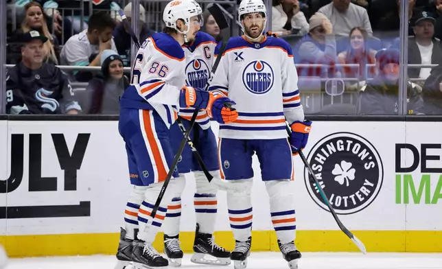 Edmonton Oilers defenseman Evan Bouchard (2), right, is congratulated by right wing David Tomasek (86) after scoring against the Seattle Kraken in the second period of an NHL hockey game Saturday, Oct. 25, 2025, in Seattle. (AP Photo/John Froschauer)