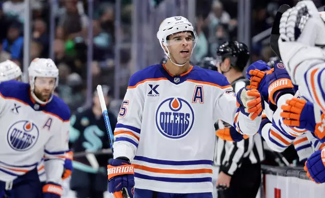 Edmonton Oilers defenseman Darnell Nurse (25) is greeted at the bench after scoring against the Seattle Kraken in the third period of an NHL hockey game Saturday, Oct. 25, 2025, in Seattle. (AP Photo/John Froschauer)