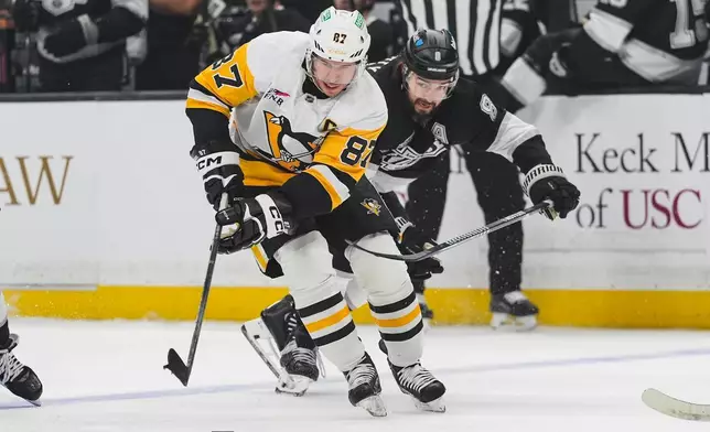 Pittsburgh Penguins center Sidney Crosby (87) is defended by Los Angeles Kings defenseman Drew Doughty (8) during the first period of an NHL hockey game Thursday, Oct. 16, 2025, in Los Angeles. (AP Photo/Jae C. Hong)