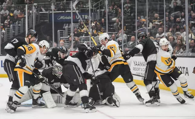 Players scramble for the puck during the first period of an NHL hockey game between the Los Angeles Kings and the Pittsburgh Penguins Thursday, Oct. 16, 2025, in Los Angeles. (AP Photo/Jae C. Hong)