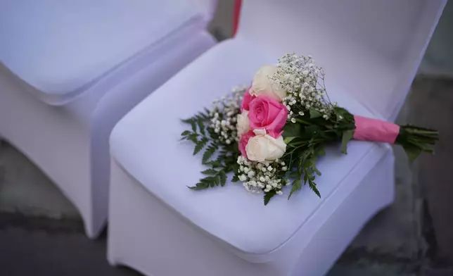 FILE - A bouquet of flowers rests on a chair ahead of a Valentine's Day group wedding ceremony at the Dade County Courthouse in Miami, Friday, Feb. 14, 2025. (AP Photo/Rebecca Blackwell, File)
