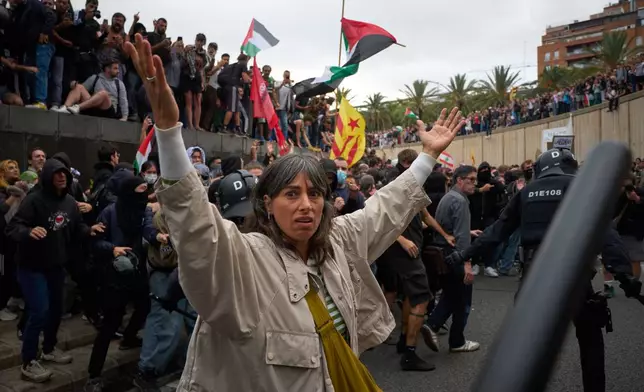 Police clash with pro-Palestinian demonstrators during a protest in Barcelona, Spain, Thursday. Oct. 2, 2025 in solidarity with the Global Sumud Flotilla after ships were intercepted by the Israeli navy. (AP Photo/Emilio Morenatti)
