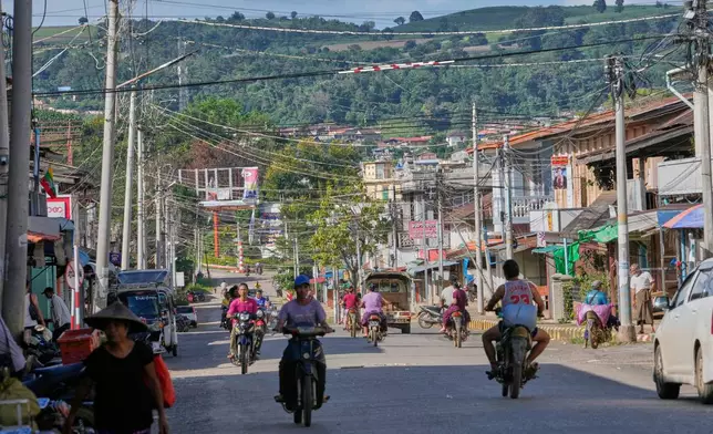 In this photo taken during a trip supervised by pro-military Myanmar media, locals ride motorbikes in Kyaukme, northern Shan State, Myanmar, Friday, Oct. 10, 2025. (AP Photo/Aung Shine Oo)