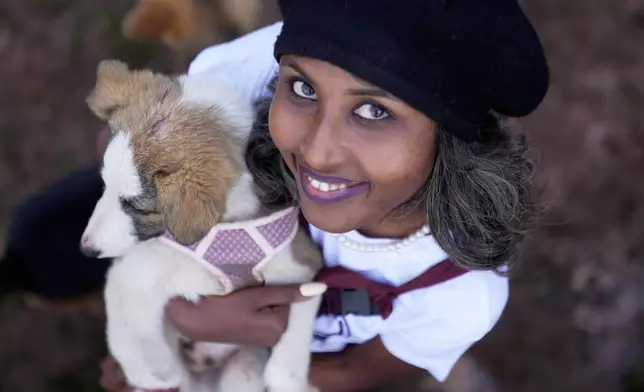 Feven Melesein, 29-years-old, holds a dog that was abandoned on the streets of the capital, Addis Ababa, Ethiopia, Sunday, Sept. 7, 2025. (AP Photo/Brian Inganga)