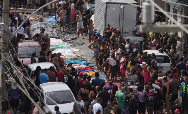 Residents look at the bodies of people killed the day before during a police raid targeting the Comando Vermelho gang at the Complexo da Penha favela in Rio de Janeiro, Brazil, Wednesday, Oct. 29, 2025. (AP Photo/Silvia Izquierdo)