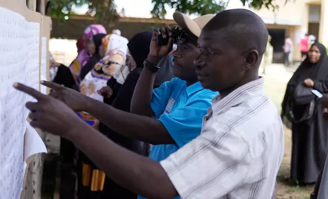 Voters verify their names before voting during the general elections at Mpendaye polling station in Zanzibar, Tanzania, Wednesday, Oct. 29, 2025. (AP Photo/Brian Inganga)