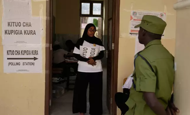 A police officer stands at the door during the counting of votes at Haile Selassie polling station in Zanzibar, Tanzania, Wednesday, Oct. 29, 2025. (AP Photo/Brian Inganga)
