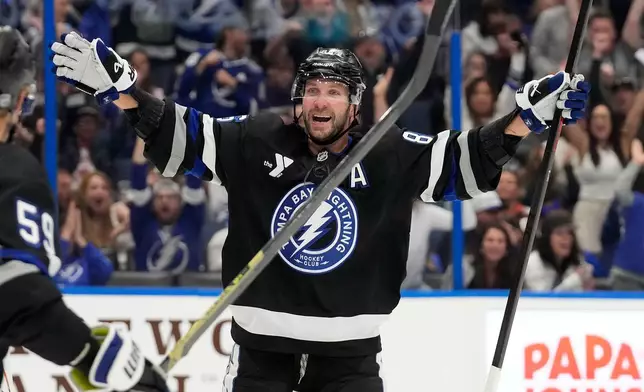 Tampa Bay Lightning right wing Nikita Kucherov (86) celebrates after picking up assist for his 1,000th career point on a goal by center Brayden Point during the second period of an NHL hockey game against the Anaheim Ducks Saturday, Oct. 25, 2025, in Tampa, Fla. (AP Photo/Chris O'Meara)