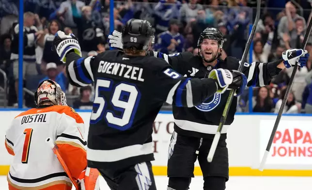 Tampa Bay Lightning right wing Nikita Kucherov, right, celebrates with center Jake Guentzel after picking up an assist for his 1,000th career point on a goal by center Brayden Point on Anaheim Ducks goaltender Lukas Dostal (1) during the second period of an NHL hockey game Saturday, Oct. 25, 2025, in Tampa, Fla. (AP Photo/Chris O'Meara)