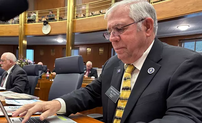 FILE - North Dakota Republican state Rep. Bill Tveit works at his desk, Jan. 22, 2025, in the House of Representatives at the state Capitol in Bismarck, N.D. (AP Photo/Jack Dura, File)