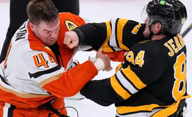 Boston Bruins left wing Tanner Jeannot (84) lands a punch in a fight against Anaheim Ducks left wing Ross Johnston (44) during the second period of an NHL hockey game, Thursday, Oct. 23, 2025, in Boston. (AP Photo/Charles Krupa)
