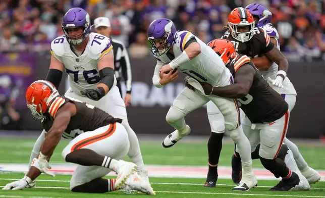 Minnesota Vikings quarterback Carson Wentz (11) is tackled during the second half of the NFL game between Minnesota Vikings and Cleveland Browns at the Tottenham Hotspur stadium in London, Sunday, Oct. 5, 2025. (AP Photo/Kirsty Wigglesworth)