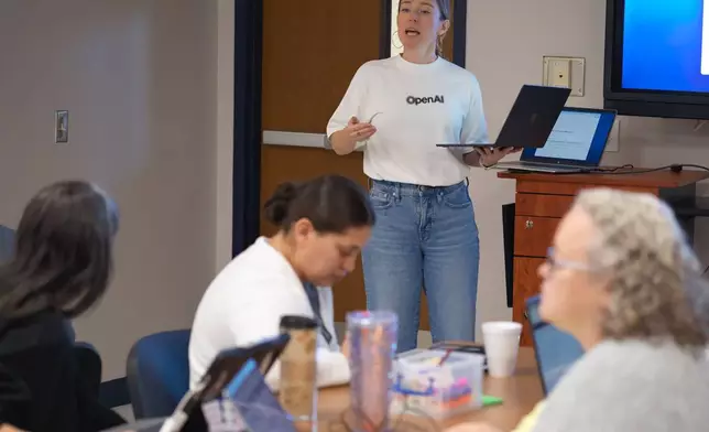 Natalie Cone, head of OpenAI Forum, center, speaks with attendees during a Microsoft AI skilling event, Saturday, Sept. 27, 2025, in San Antonio. (AP Photo/Darren Abate)