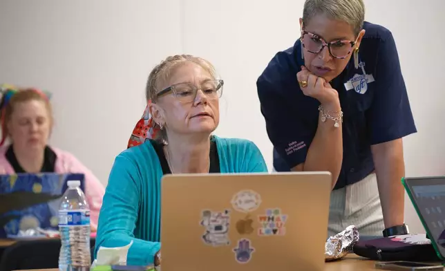 Northside American Federation of Teachers President Melina Espiritu-Azocar, right, speaks with middle school teacher Celeste Simone during a Microsoft AI skilling event, Saturday, Sept. 27, 2025, in San Antonio. (AP Photo/Darren Abate)