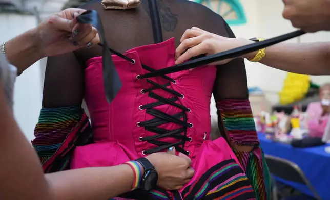 Drag artists prepare a costume ahead of the annual Day of the Dead Catrina parade in Mexico City, Sunday, Oct. 26, 2025. (AP Photo/Claudia Rosel)