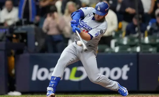 Los Angeles Dodgers' Max Muncy hits a home run against the Milwaukee Brewers during the sixth inning in Game 2 of baseball's National League Championship Series, Tuesday, Oct. 14, 2025, in Milwaukee. (AP Photo/Ashley Landis)