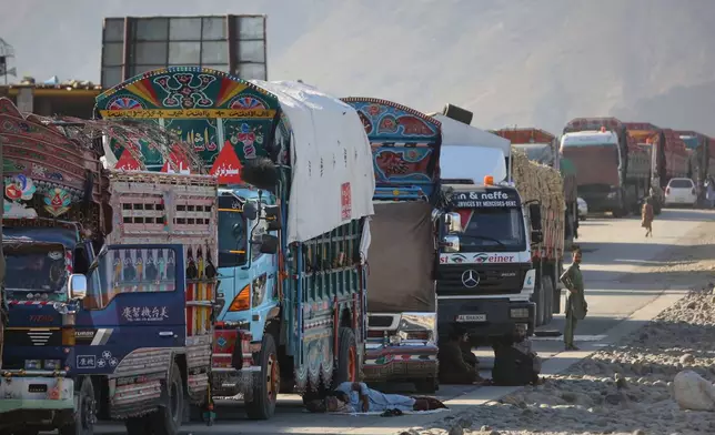 A line of cargo trucks bound for Pakistan is stranded on the Afghan side of the Torkham border crossing, which remained closed after clashes, in Nangarhar province, Afghanistan, Tuesday, Oct. 14, 2025. (AP Photo/Wahidullah Kakar)