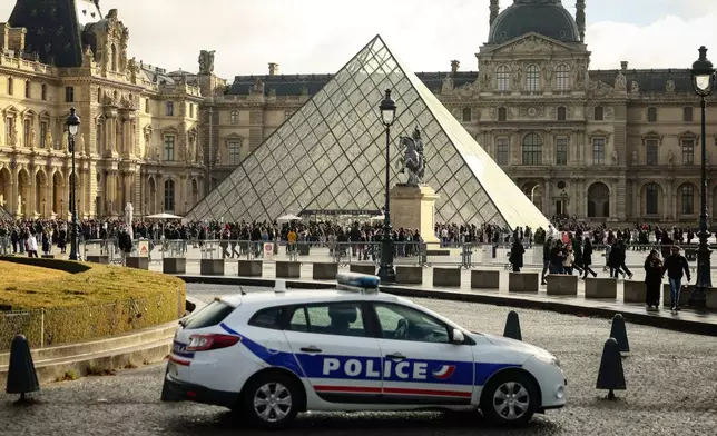 A police car parks in the courtyard of the Louvre museum, one week after the robbery, Sunday, Oct. 26, 2025 in Paris. The Paris prosecutor said on Sunday that a number of suspects have been arrested over the theft of crown jewels from Paris' Louvre museum last weekend. (AP Photo/Thomas Padilla)