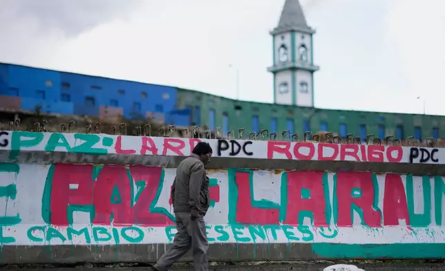 A man walks past a mural promoting presidential candidate Rodrigo Paz days ahead of the runoff election, in El Alto, Bolivia, Thursday, Oct. 16, 2025. (AP Photo/Natacha Pisarenko)