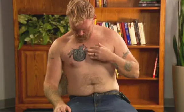 In this photo provided by WGME, Graham Platner, a democratic candidate for U.S. Senate, points to a cover-up tattoo that had previously been an image recognized as a Nazi symbol, during an interview on Wednesday, Oct. 22, 2025, in Portland, Maine. (WGME via AP)