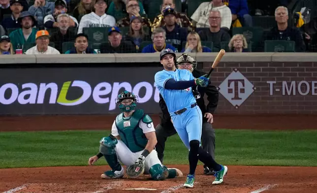 Toronto Blue Jays' George Springer follows through on an RBI double against the Seattle Mariners during the fifth inning in Game 5 of baseball's American League Championship Series, Friday, Oct. 17, 2025, in Seattle. (AP Photo/David J. Phillip)