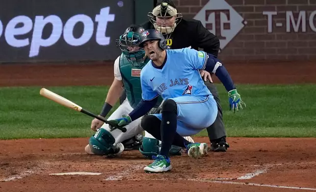 Toronto Blue Jays' George Springer falls after being hit by a pitch against the Seattle Mariners during the seventh inning in Game 5 of baseball's American League Championship Series, Friday, Oct. 17, 2025, in Seattle. (AP Photo/David J. Phillip)
