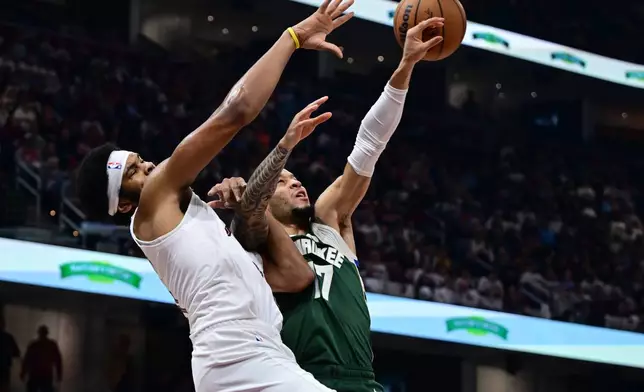 Milwaukee Bucks guard Amir Coffey, right, knocks the ball away from Cleveland Cavaliers center Jarrett Allen, left, in the first half of an NBA basketball game Sunday, Oct. 26, 2025, in Cleveland. (AP Photo/David Dermer)