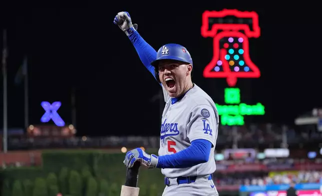 Los Angeles Dodgers' Freddie Freeman reacts after Teoscar Hernández hit a three-run home run off Philadelphia Phillies pitcher Matt Strahm during the seventh inning in Game 1 of baseball's National League Division Series, Saturday, Oct. 4, 2025, in Philadelphia. (AP Photo/Matt Rourke)