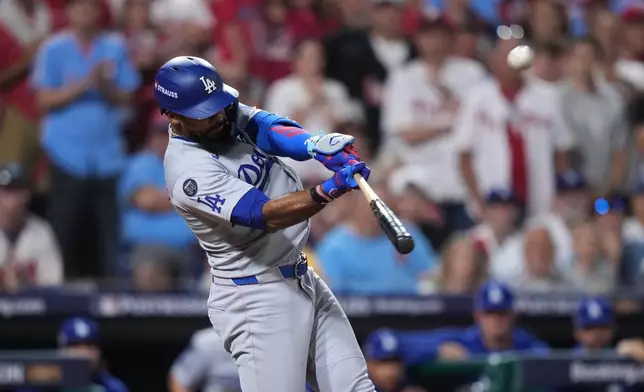 Los Angeles Dodgers' Teoscar Hernández hits a three-run home run against Philadelphia Phillies pitcher Matt Strahm during the seventh inning in Game 1 of baseball's National League Division Series, Saturday, Oct. 4, 2025, in Philadelphia. (AP Photo/Matt Slocum)
