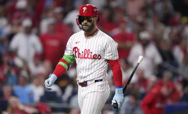 Philadelphia Phillies' Bryce Harper walks back to the dugout after striking out against Los Angeles Dodgers pitcher Shohei Ohtani during the sixth inning in Game 1 of baseball's National League Division Series, Saturday, Oct. 4, 2025, in Philadelphia. (AP Photo/Matt Slocum)