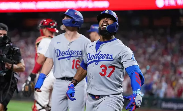 Los Angeles Dodgers' Teoscar Hernández reacts after hitting a three-run home run off of Philadelphia Phillies pitcher Matt Strahm during the seventh inning in Game 1 of baseball's National League Division Series, Saturday, Oct. 4, 2025, in Philadelphia. (AP Photo/Matt Rourke)