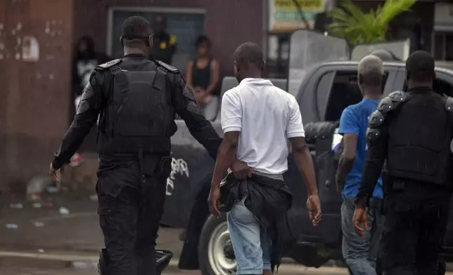 Police arrest a protester during clashes with opposition supporters in Abidjan, Ivory Coast, Saturday, Oct. 11, 2025 (AP Photo/Diomande Ble Blonde)
