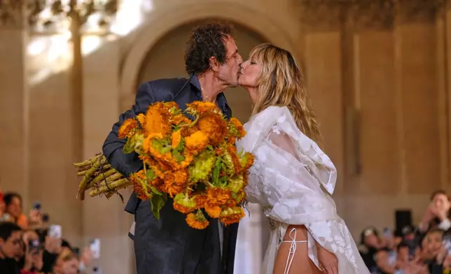 Designer Andreas Kronthaler, left, kisses Heidi Klum after the Vivienne Westwood Spring/Summer 2026 collection presented in Paris, Saturday, Oct. 4, 2025. (AP Photo/Aurelien Morissard)