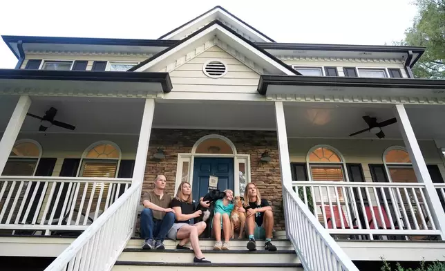 Meaghan and Chris Marr pose with their children and dogs for a photograph on Thursday, Sept. 25, 2025, in Cartersville, Ga. (AP Photo/Brynn Anderson)