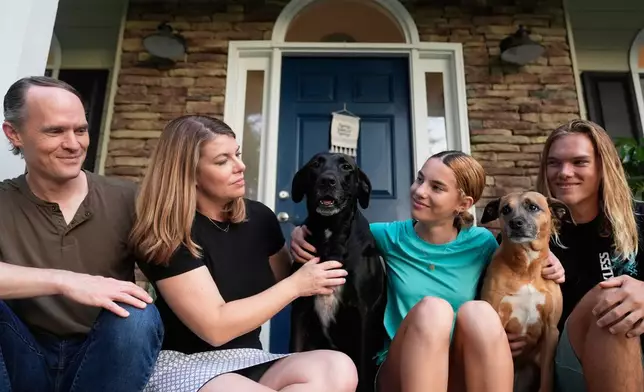 Meaghan and Chris Marr pose with their children and dogs for a photograph on Thursday, Sept. 25, 2025, in Cartersville, Ga. (AP Photo/Brynn Anderson)